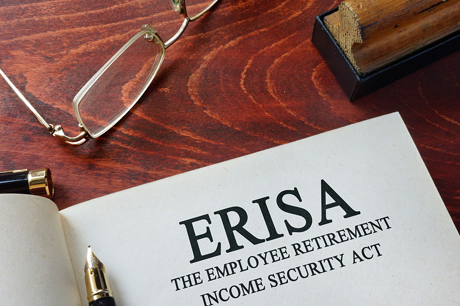 ERISA book on a desk with reading glasses